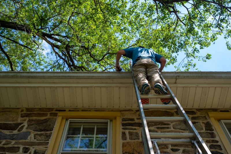 Worker Installing Gutter on Roof